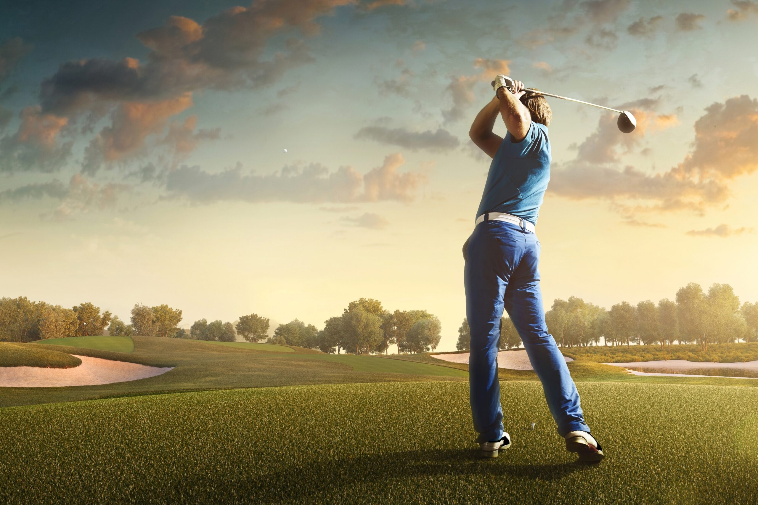 Capture the thrill of golf with this high-resolution image showcasing a golfer in mid-swing on a lush green fairway. The golfer, dressed in modern athletic wear, demonstrates perfect form as they stri